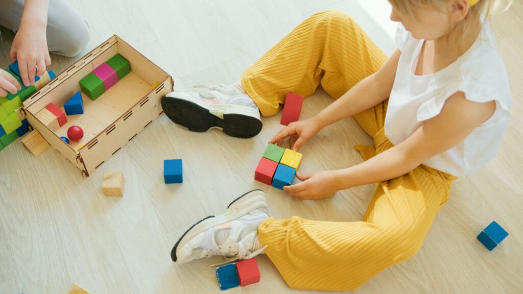 pexels photo 8088104 A young child playing creatively with colorful wooden blocks indoors, fostering learning and development.